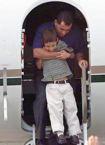 Padre e hijo suben al avión en Washington DC que los traerá de vuelta a Cuba. Foto: AFP.
