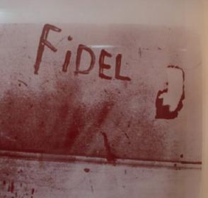El miliciano Eduardo García Delgado, víctima del criminal bombardeo en las bases aéreas cubanas, escribe con sangre el nombre de Fidel, el 15 de abril de 1961.