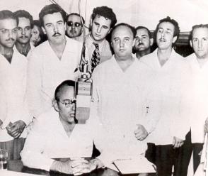 Eduardo Chibás en una de sus alocuciones radiales. De pie, en primera fila (tercero de derecha a izquierda), Roberto Agramonte. Detrás de este, el joven abogado Fidel Castro. (Foto: Autor no identificado)
